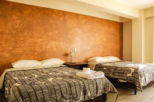塔里哈Hostal Sky的酒店客房带两张床和一面墙