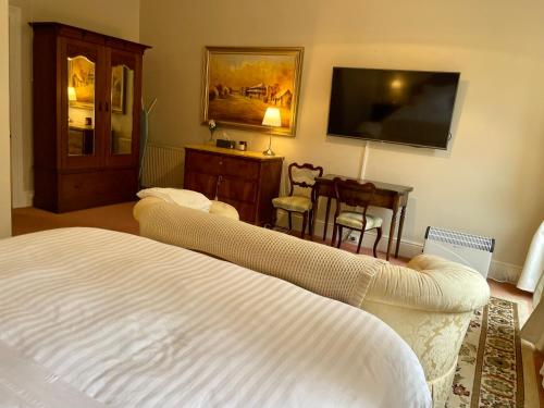 黑荒地Rowan Brae Historic Guesthouse的一间卧室配有一张床和一台平面电视