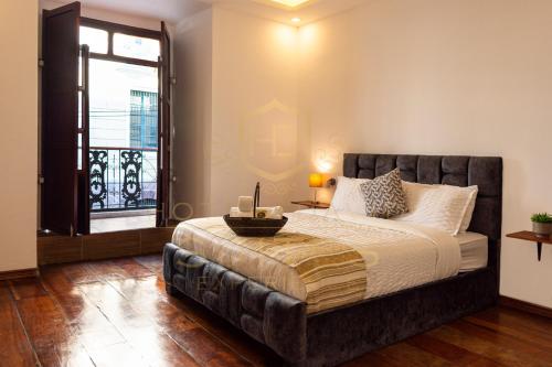 基多Suites Experience by Hotel David的一间卧室设有一张大床和一个窗户。