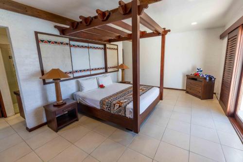 拉奇拉奇Villa Vanua - Private Luxury Villa的一间卧室配有天蓬床和床头柜