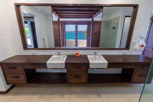 拉奇拉奇Villa Vanua - Private Luxury Villa的一间带两个盥洗盆和大镜子的浴室