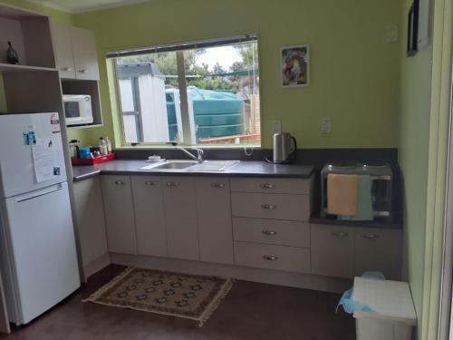 芒阿法埃Quail's Nest的厨房配有水槽、冰箱和窗户。