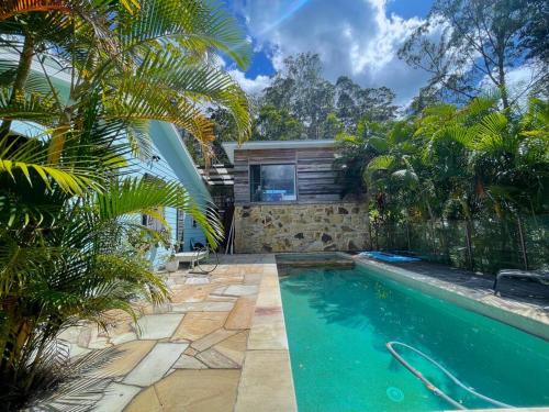 UkiGolden Retreat Ultimate 5 Bed - Villa & Guesthouse的花园内的游泳池,带房子