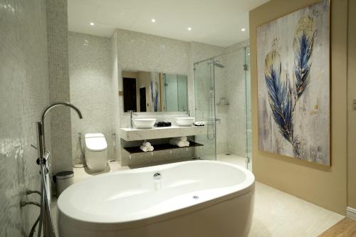 顺化Millennium Hue Hotel的带浴缸、水槽和镜子的浴室