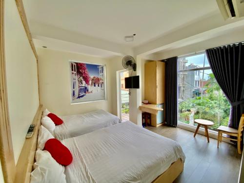 顺化Hue Four Seasons Hotel的一间卧室设有一张床和一个大窗户