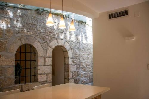 耶路撒冷Cozy Heritage Home Jerusalem的一间设有桌子和石墙的房间