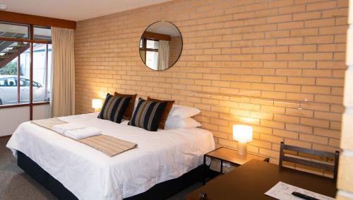 克莱尔Bentley's Hotel的一间卧室设有一张床和砖墙