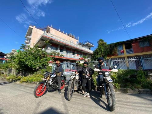 博卡拉Hotel Mountain View - Lakeside Pokhara的三人骑摩托车停在大楼前