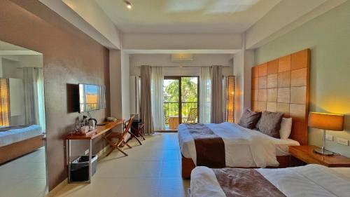 长滩岛长滩岛阿罗哈酒店的酒店客房 - 带两张床、一张桌子和一张床