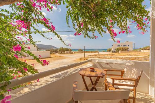 AgiassosStudios Strouvalis的阳台配有桌椅,享有海滩美景。