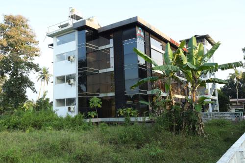 安加马尔伊Airport Cochin Grand Residency , NEDUMBASSERY的前面有大量植物的建筑