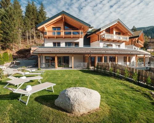 安达洛La Dila Dolomiti Mountain Lodge的一座带岩石的大院子的房子