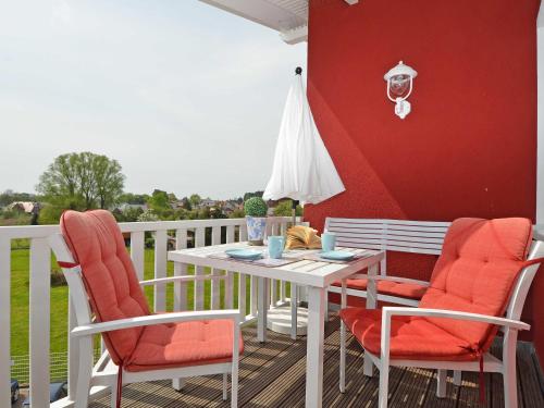 奥斯赛拜-塞林Villa "To Hus" F590 - Appartement 07 im Dachgeschoss mit Kamin und Balkon的阳台上配有白色的桌椅