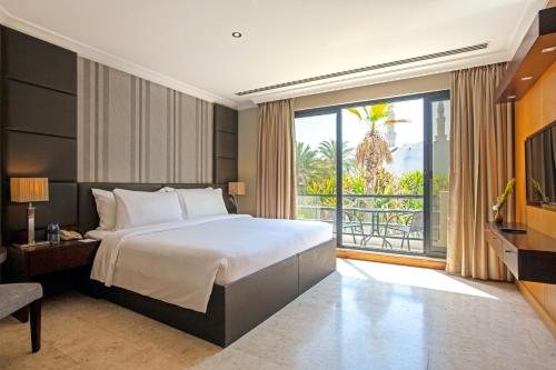 迪拜迪拜海滩Spa度假酒店的一间卧室设有一张大床和一个大窗户