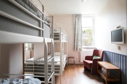 哥德堡Kvibergs Vandrarhem - Hostel的一间小房间,配有双层床和沙发