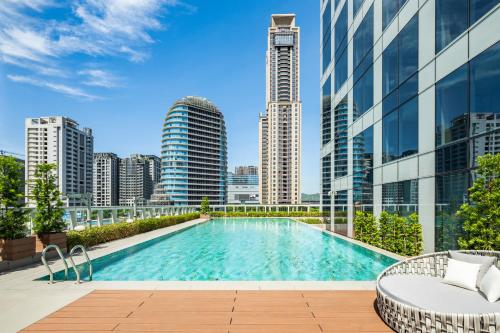 新庄新北新庄凯悦嘉轩酒店的一座城市天际线建筑屋顶上的游泳池