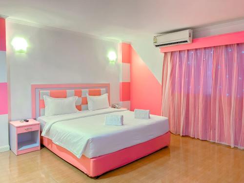 SadaoThe Wai Hotel Danok的粉红色和白色的卧室配有大床
