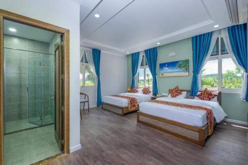 富国V&T Hotel的一间卧室设有两张床和淋浴。