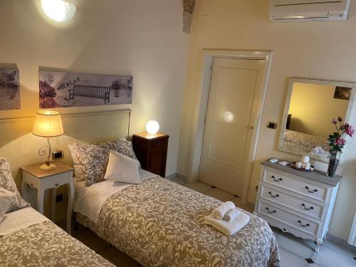 梅萨涅Porta Piccola B&B的一间小卧室,配有两张床和镜子