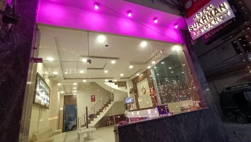阿姆利则Hotel Sukhman Residency的建筑中带紫色灯的商店窗口