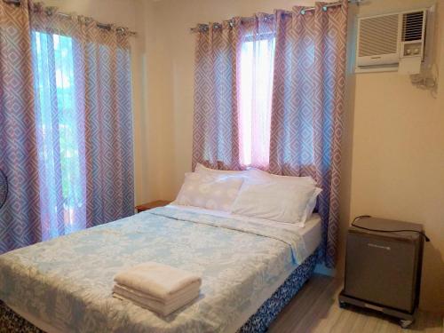 班塔延岛Solsken Guest House的一间卧室配有床、两个窗户和毛巾