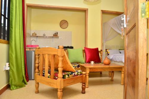 阿鲁沙Heart Of Africa Adventure and Apartments的客厅配有椅子和床