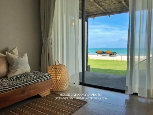 恰洛克拉姆Silan Residence, Koh Phangan - An authentic village experience的一间卧室配有一张床,享有海滩美景