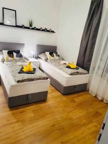 林茨Leon 3 wunderschönes neues Apartment的配有2张床的木地板客房