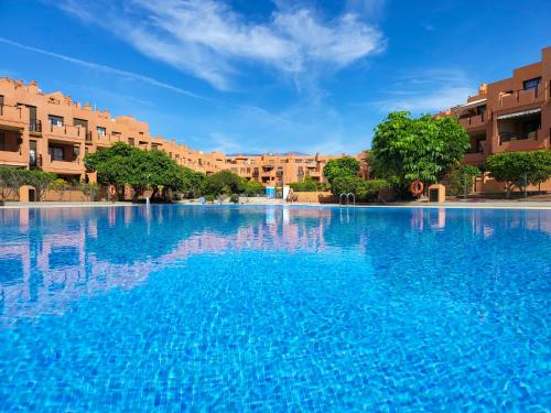 拉特吉塔MEDANO4YOU La Terraza De Isa的一个大型蓝色游泳池,其建筑背景为:
