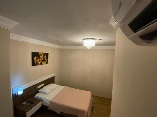 阿达纳DUVAHi OTEL KONAKLAMA的一间带一张床和吊灯的小卧室