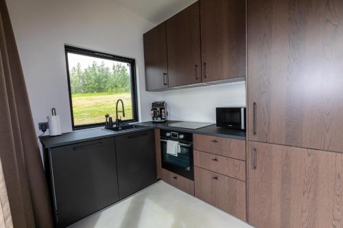 阿克雷里North Mountain View Suites的厨房配有木制橱柜和窗户。