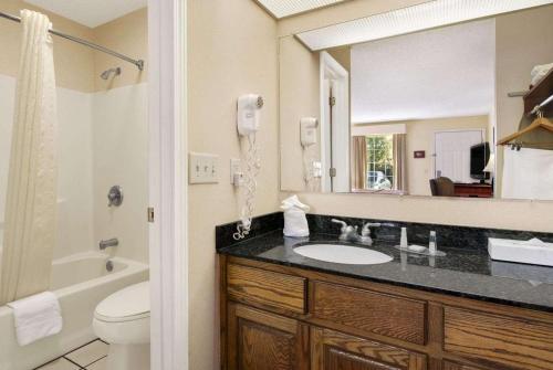 尤福拉Baymont by Wyndham Eufaula的一间带水槽、卫生间和镜子的浴室