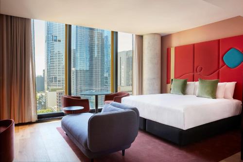 墨尔本Quincy Hotel Melbourne的酒店客房设有一张床和一个大窗户
