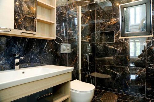达利安Stunning 4 bedrooms Luxury Villa Kaan Dalyan的黑色大理石浴室设有水槽和卫生间