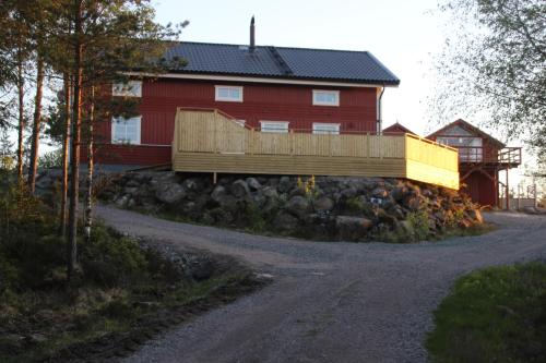 BäckeforsLillesjö stuguthyrning的路边的红色房子,带有木栅栏