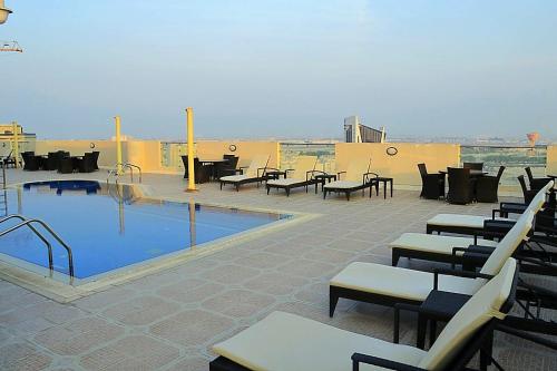 多哈Wonder Palace Hotel Qatar的庭院设有游泳池和桌椅