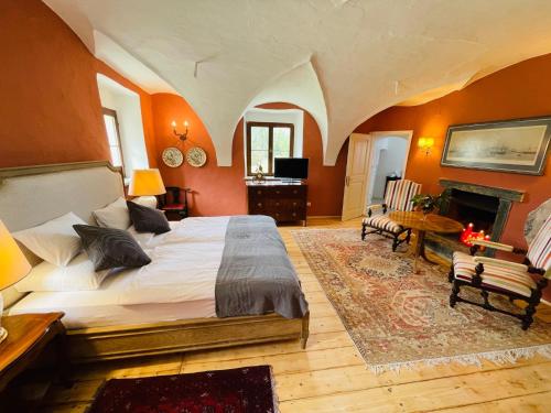 莫斯堡Schloss Moosburg Gästehaus的一间卧室设有一张大床和一个壁炉