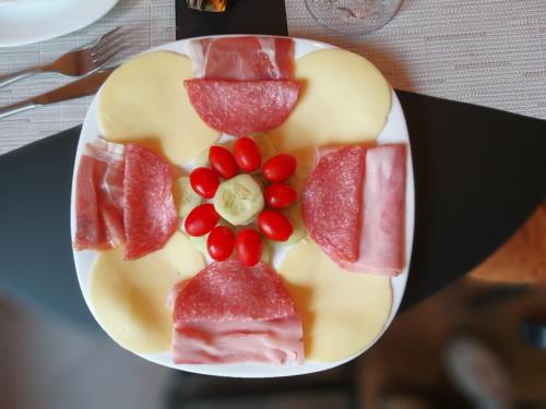 罗马B&B Le Ninfee的盘子里放着肉和水果的食物
