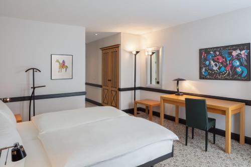穆滕茨Hotel Baslertor的配有一张床和一张书桌的酒店客房