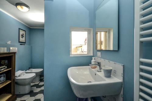 佛罗伦萨Palazzo Panzani的蓝色的浴室设有水槽和卫生间