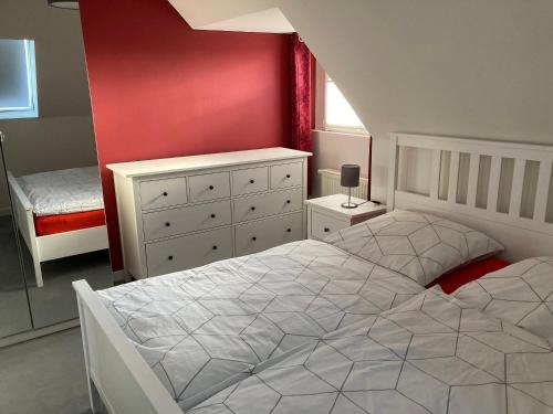 科斯费尔德Villa Am Honigbach的卧室配有白色的床和红色的墙壁
