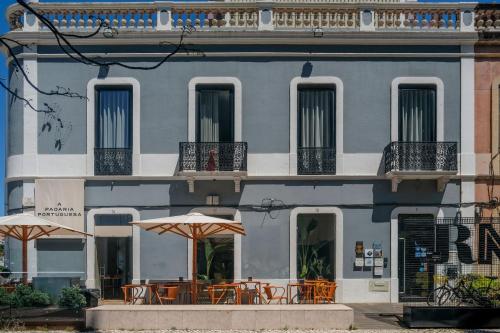 塞图巴尔RM The Experience - Small Portuguese Hotels的前面有桌子和伞的建筑