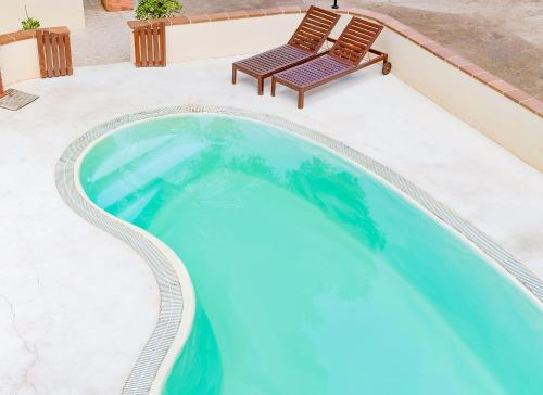 埃斯卡洛Apartamentos El Pino - Formentera Break的游泳池旁设有长凳