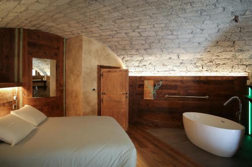 萨伊恩特-雷米-恩-博塞斯Maison Farinet的一间卧室配有一张床和浴缸