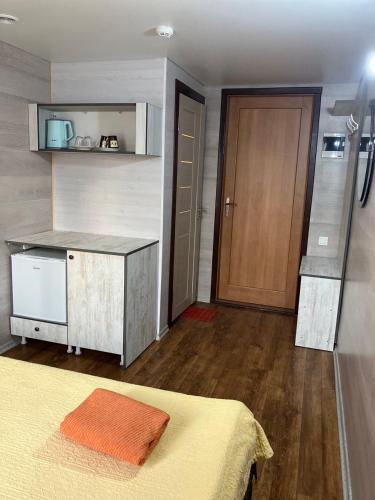 基希讷乌NewHome的一间卧室配有一张床、一间厨房和一扇门