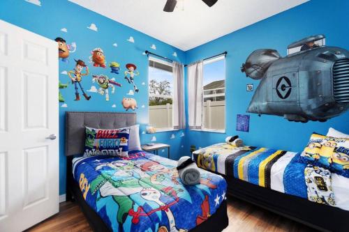达文波特Spacious Disney Themed 5Bed Villa! Private Heated Enclosed Pool/Spa/BBQ!的一间卧室设有两张床和蓝色的墙壁