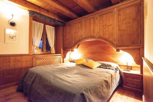 圣维托-迪卡多雷Mansarda su due livelli nel cuore delle Dolomiti的一间卧室配有一张大床和木制床头板