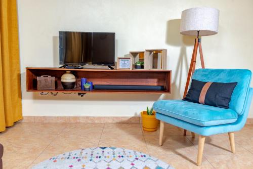 George HillLittleLux Living的客厅配有蓝色椅子和电视