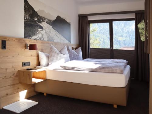 HöfenLechappart的一间卧室设有一张大床和一个窗户。