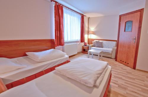 什切青城市旅馆 的酒店客房,设有两张床和一张沙发